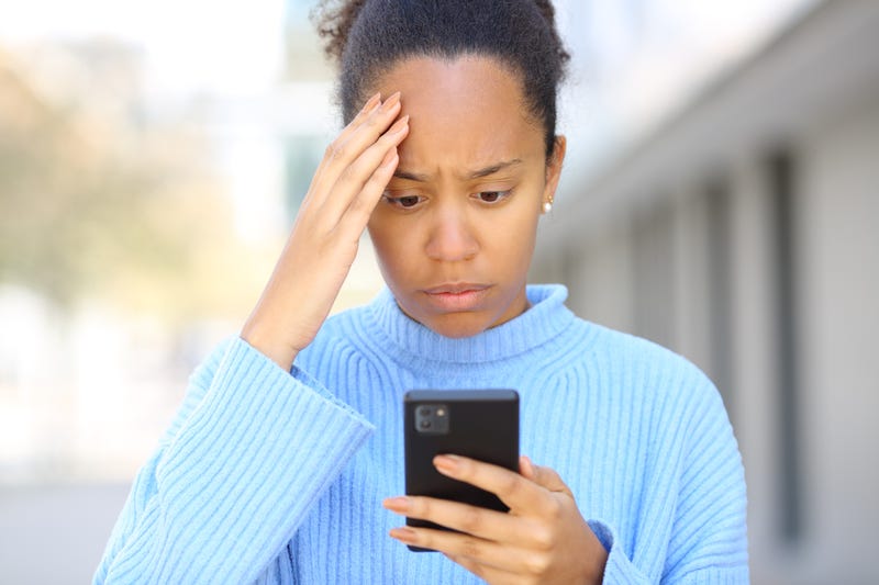 Worried black woman checking bad news on phone