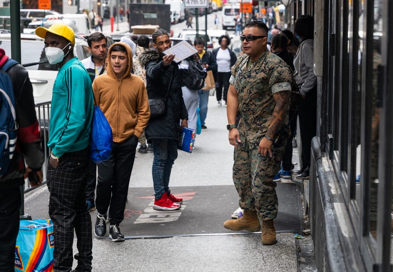 A person assists recently arrived migrants outside of the Roosevelt Hotel in Midtown Manhattan on Sept. 28, 2023