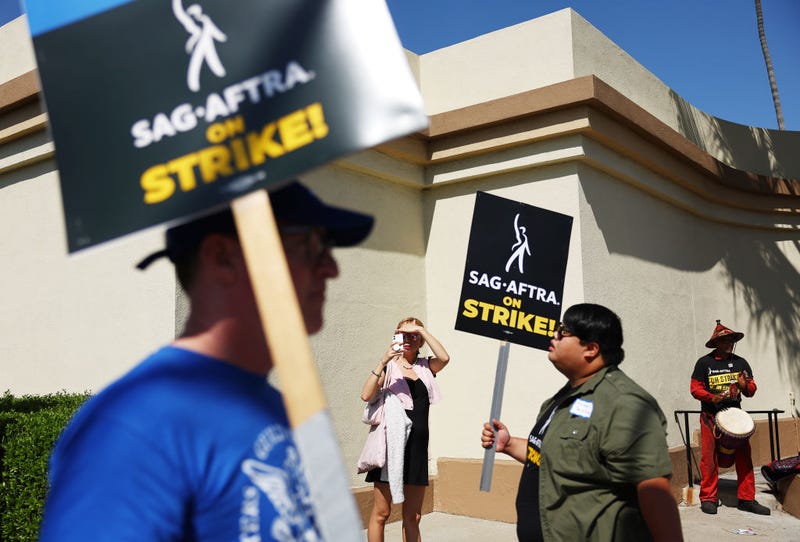 A person takes photos as striking SAG-AFTRA members picket with WGA (Writers Guild of America) members marching in solidarity outside Paramount Studios on October 02, 2023 in Los Angeles, California