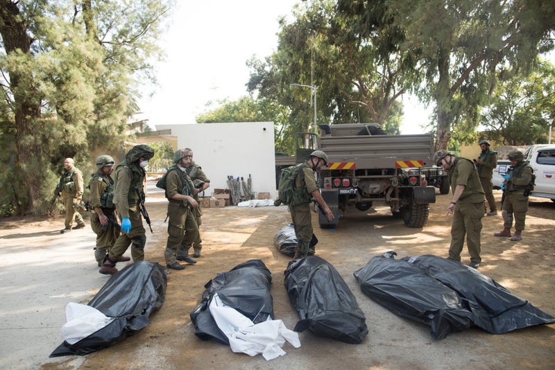 Israeli soldiers remove the bodies of civilians, who were killed days earlier in an attack by Palestinian militants on this kibbutz near the border with Gaza
