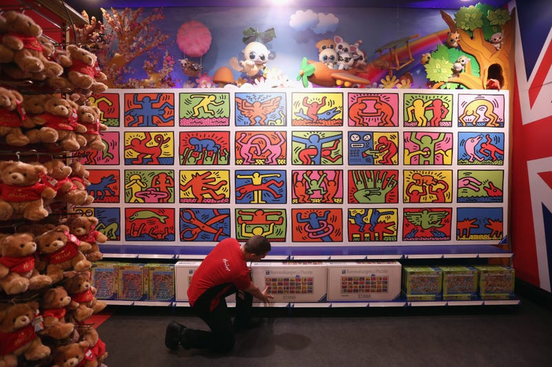 An employee adjusts a box for the 32,256-piece Keith Haring jigsaw, beneath the completed puzzle, in Hamleys toy shop on June 27, 2013, in London, England.