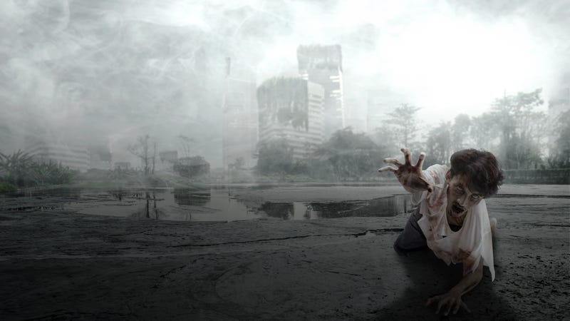 A scary zombie with blood and wounds on his body is crawling in the ruined city. Scary zombie. Halloween concept