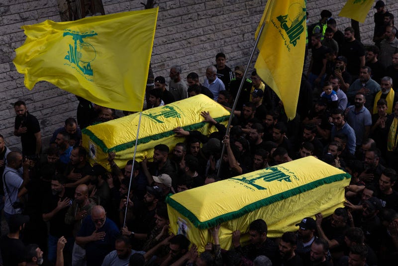 People carrying the coffins as the precession makes its way to the cemetery at a funeral for two Hezbollah soldiers who were killed yesterday by Israel Defense Forces in South Lebanon on October 10, 2023 in Khirbet Selm, Lebanon. At least three Hezbollah militants were killed in southern Lebanon near the border on October 9 in an exchange of fire with Israel. In the wake of a large-scale Hamas attack on Israel, which promoted a declaration of war from the Israeli prime minister, an Israeli officer and militants of the Iran-backed Hezbollah were killed in deadly skirmishes along the Israel-Lebanese border. (Photo by Daniel Carde/Getty Images)