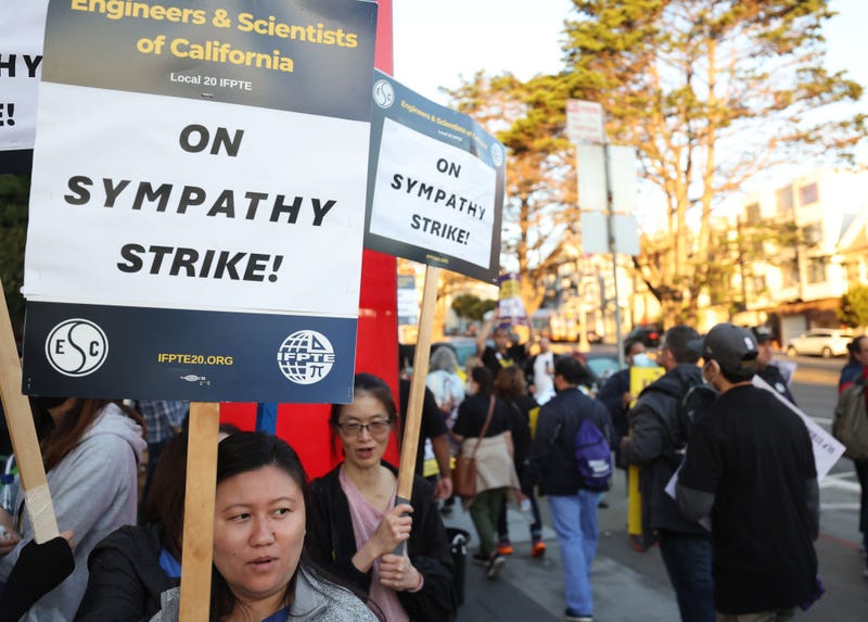 Striking Kaiser Permanente workers hold signs as they march in front of the Kaiser Permanente San Francisco Medical Center on October 04, 2023 in San Francisco, California.