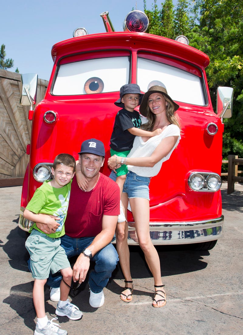 tom brady, gisele bundchen and fam posing with red the fire truck at cars land in disney california 