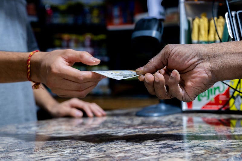 A customer purchases a Powerball lottery ticket at the Brew Market & Cafe on October 10, 2023 in Austin, Texas. The Powerball jackpot has grown to over $1.7 billion, making it the second largest jackpot in history. (Photo by Brandon Bell/Getty Images)