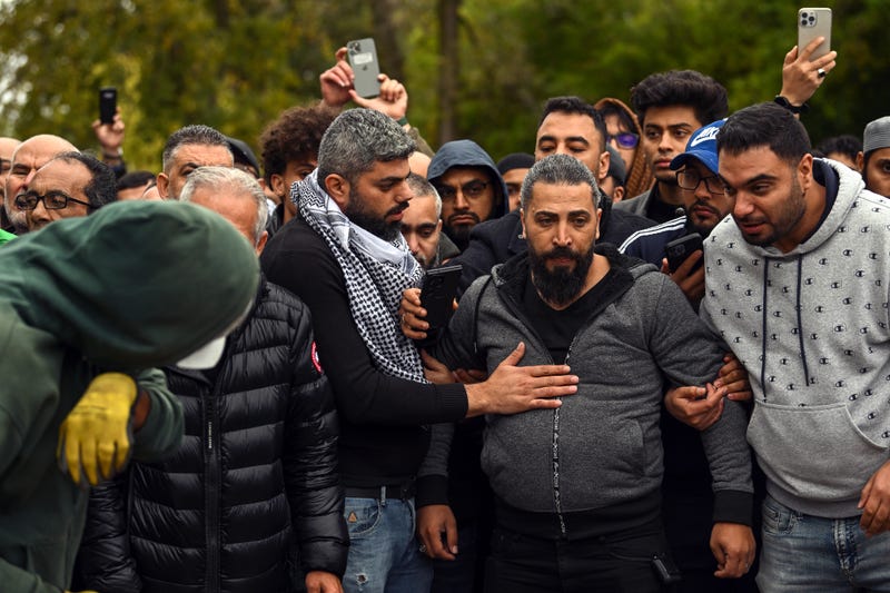 Oday Al-Fayoume (center in gray hoodie) watches as his son Wadea Al-Fayoume, 6, is buried at the Parkholm Cemetery in LaGrange, Ill.