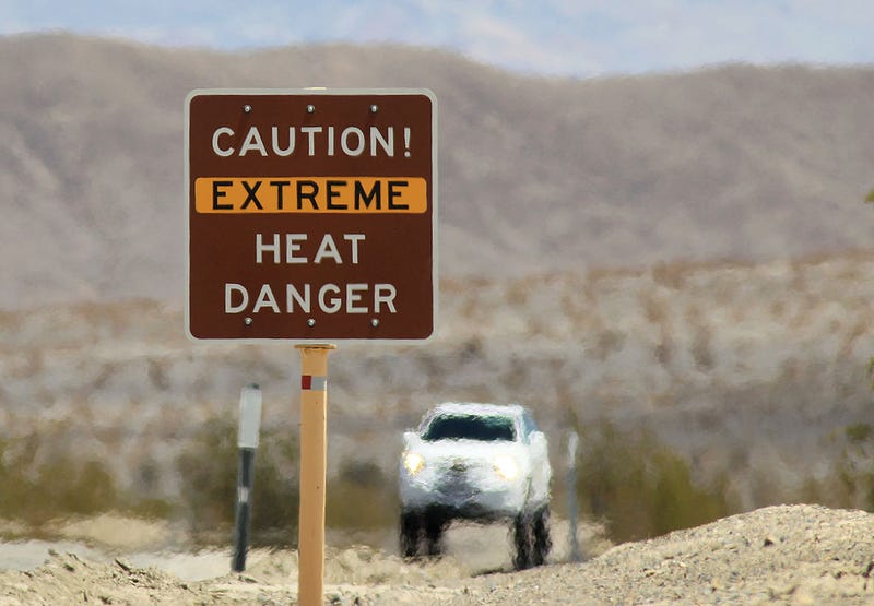 Heat waves rise near a heat danger warning sign on the eve of the AdventurCORPS Badwater 135 ultra-marathon race on July 14, 2013 in Death Valley National Park, California.
