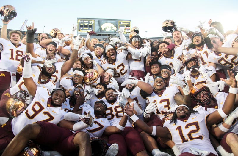 Members of the Minnesota Golden Gophers celebrate with the Floyd of Rosedale trophy after their match-up against the Iowa Hawkeyes at Kinnick Stadium on October 21, 2023 in Iowa City, Iowa.