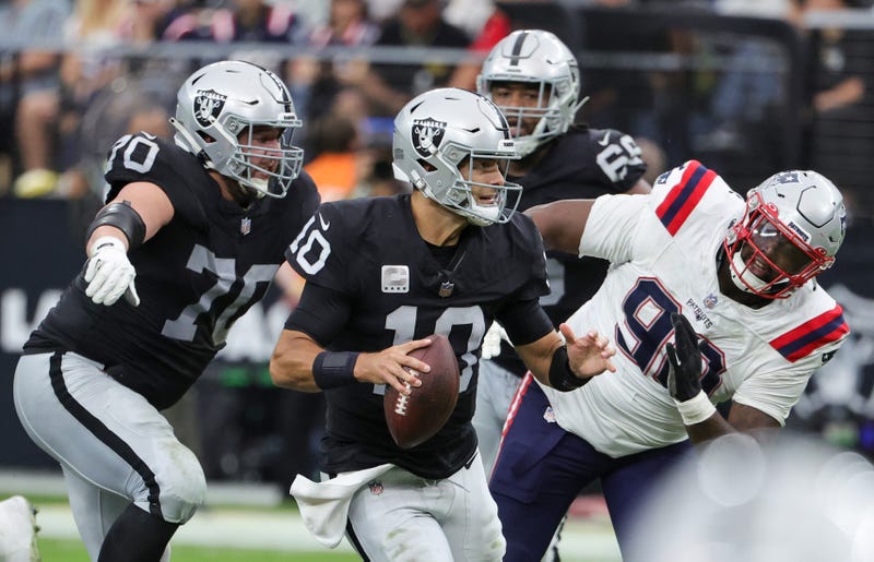 Quarterback Jimmy Garoppolo #10 of the Las Vegas Raiders runs against defensive tackle Christian Barmore #90 of the New England Patriots in the second quarter of their game at Allegiant Stadium on October 15, 2023