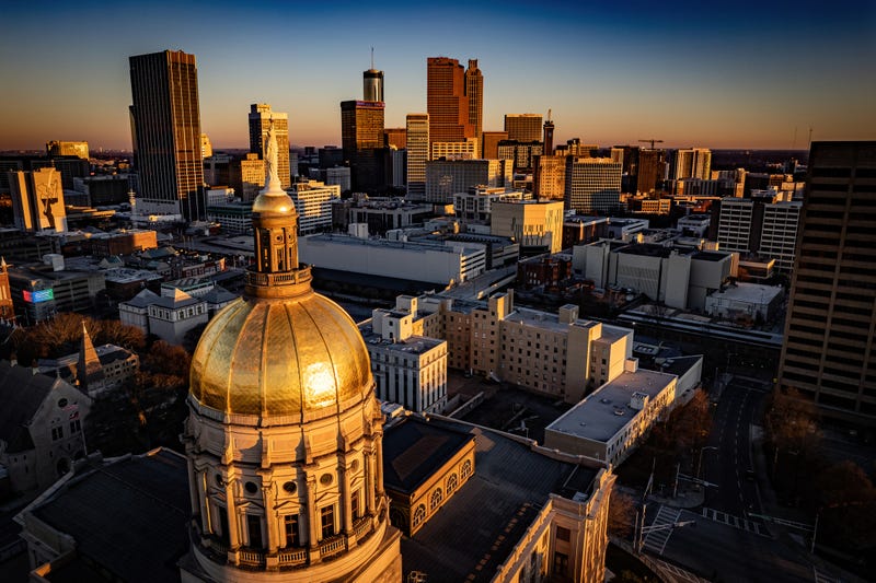 State of Georgia Capitol building in morning sunlight with the downtown cityscape of Atlanta in the background.
