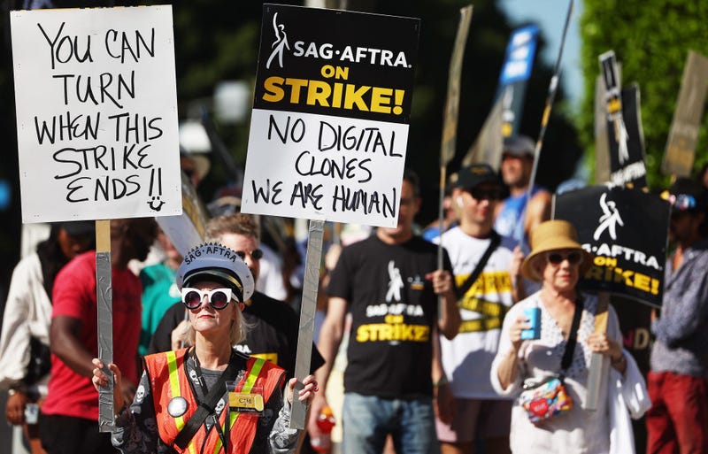 Strike captain SAG-AFTRA member Cari Ciotti (L) holds signs as striking SAG-AFTRA members and supporters picket outside Paramount Studios on day 95 of their strike against the Hollywood studios on October 16, 2023 in Los Angeles, California.