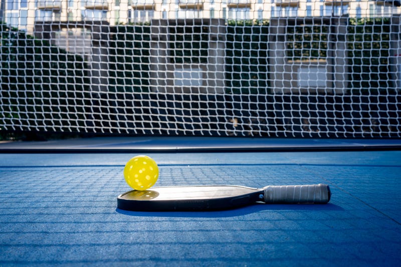 pickleball paddle and ball on court