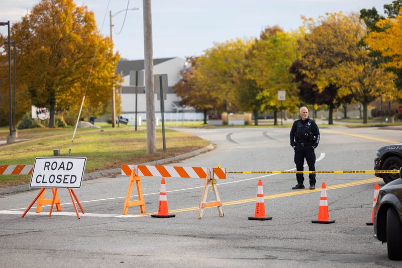 road closed sign with police tape, police officer standing