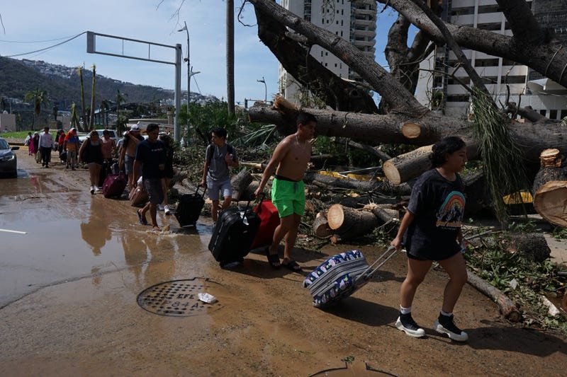People walk by a damaged area after the Hurricane Otis in Guerrero, Mexico on Oct. 26, 2023.