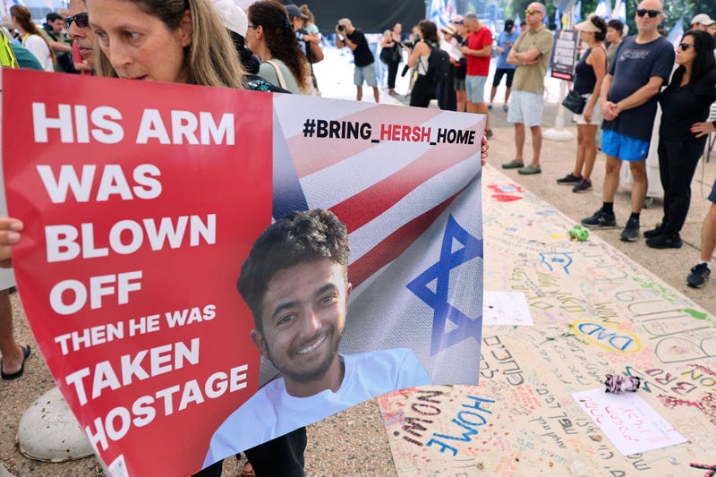 A protester holds a poster with a photo of 23-year-old US-Israeli Hersh Goldberg-Polin as people gather with signs calling for the release of hostages held by Hamas, on October 28, 2023 in Tel Aviv.