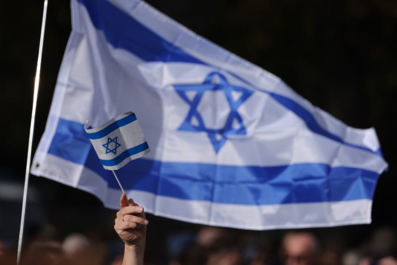 Israeli flags are waved at a rally to stop antisemitism