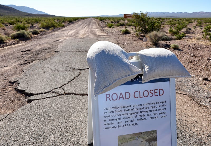 closure sign stands in front of a flood-damaged road at the recently reopened Death Valley National Park on October 22, 2023 in Death Valley National Park, California.
