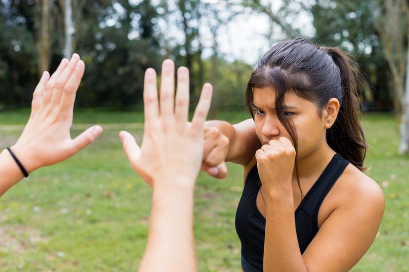 woman practicing martial arts self-defense outdoors