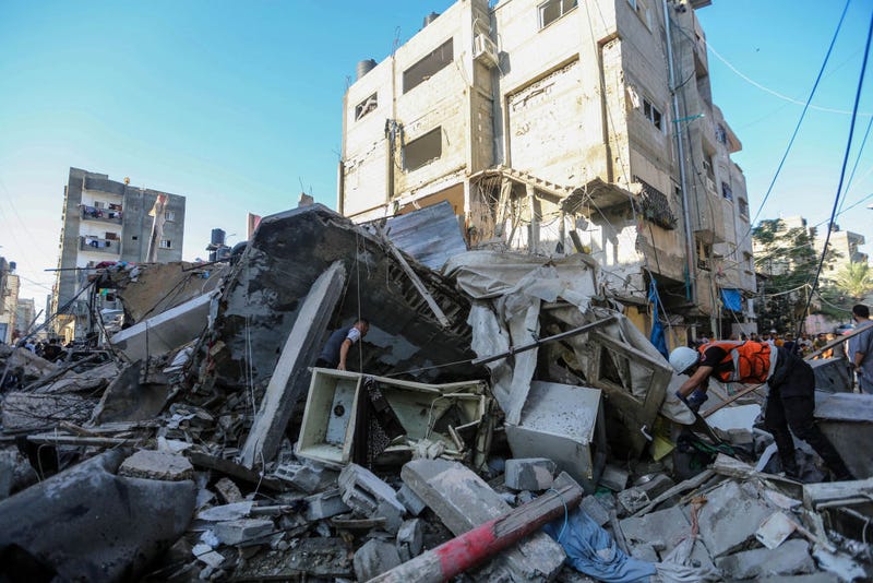 People search through buildings that were destroyed during Israeli air raids in the southern Gaza Strip on October 26, 2023 in Khan Yunis, Gaza.