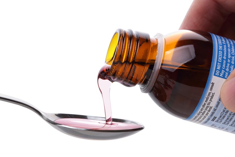 Cough syrup being poured.