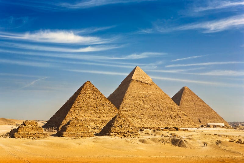 "Egypt. Cairo - Giza. General view of pyramids from the Giza Plateau (there is three pyramids popularly known as Queens' Pyramids on front side; next in order from left: the Pyramid of Menkaure /Mykerinos/, Khafre /Chephren/ and Chufu /Cheops/ - known as the Great Pyramid). The Pyramid Fields from Giza to Dahshur is on UNESCO World Heritage List"