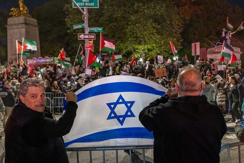 Counter-demonstrators hold an Israeli flag across the street from a pro-Palestinian rally in Midtown Manhattan on Saturday