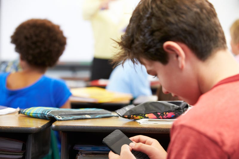 Student looking at cell phone instead of teacher