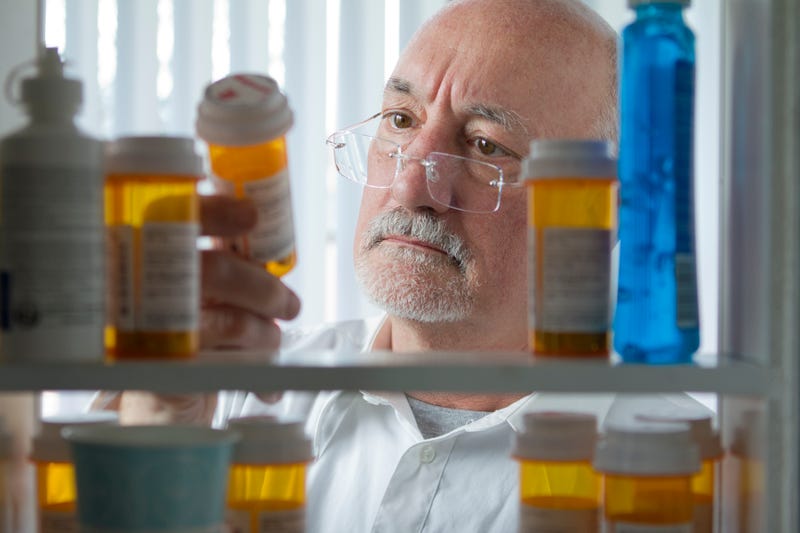 man looking in pill cabinet