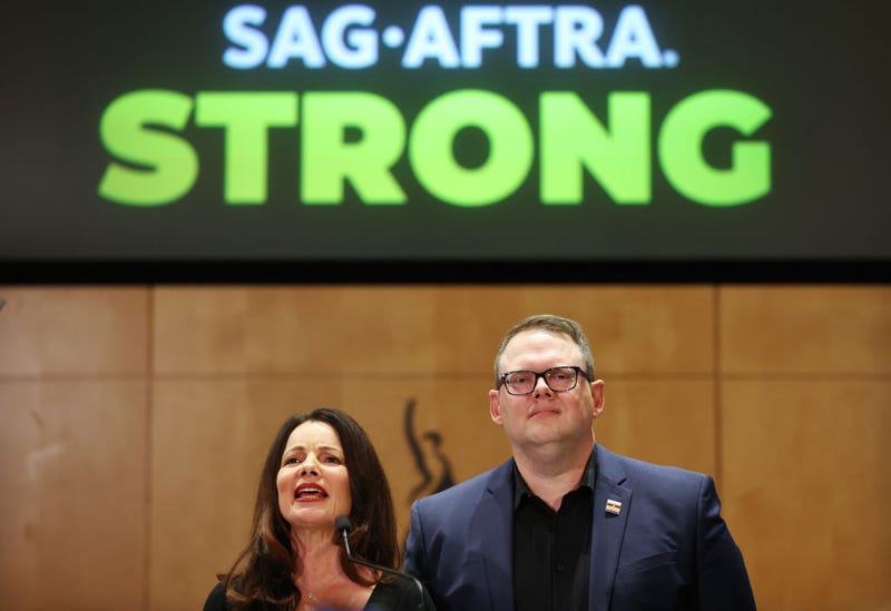  SAG-AFTRA President Fran Drescher (L) speaks as SAG-AFTRA National Executive Director Duncan Crabtree-Ireland looks on at a press conference discussing their strike-ending deal with the Hollywood studios on November 10, 2023 in Los Angeles, California.