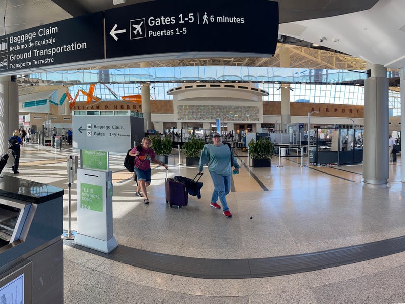 People dragging their luggage as they walk inside Houston's William P. Hobby airport, Houston, Texas, USA