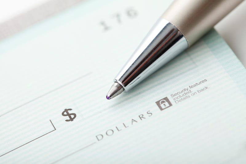 Close up photo of a pen and blank dollar check.