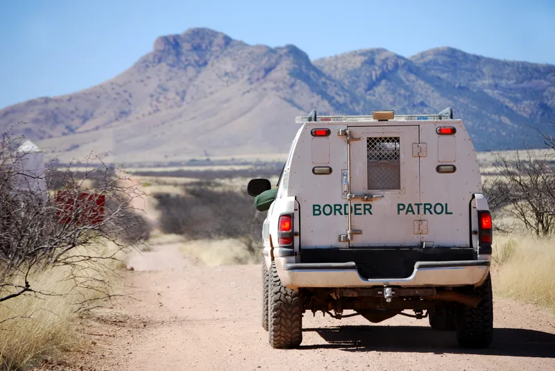 Back of a border patrol truck driving on a dirt road along the Mexican border in Arizona.