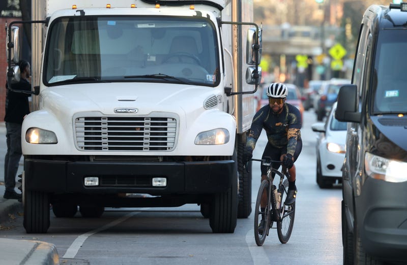 A cyclist maneuvers past a delivery truck parked in a bicycle lane in the 1500 block of North Damen Avenue on Nov. 15, 2023.