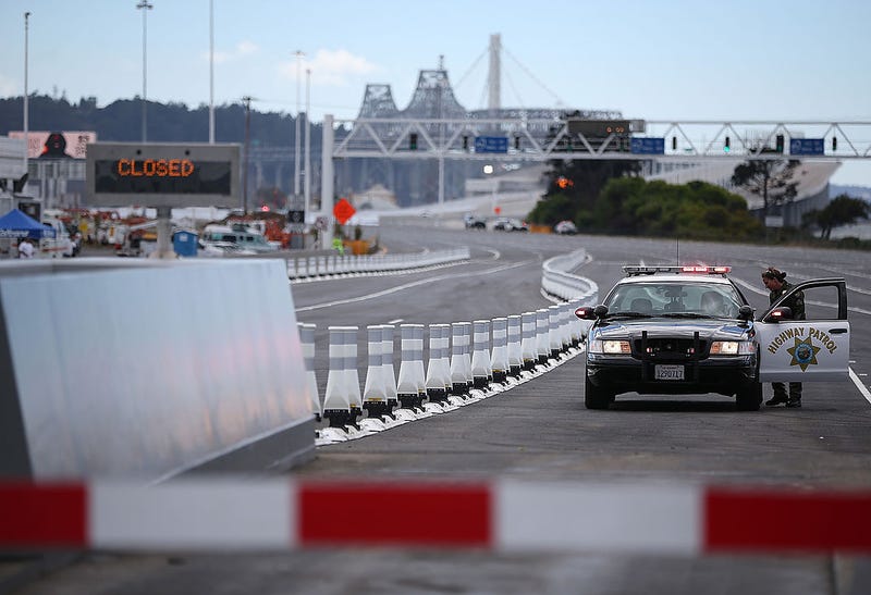 A California Highway Patrol officer blocks a toll plaza lane before a chain-cutting ceremony to officially open the new eastern span of the San Francisco Oakland Bay Bridge on August 30, 2013 in Oakland, California.