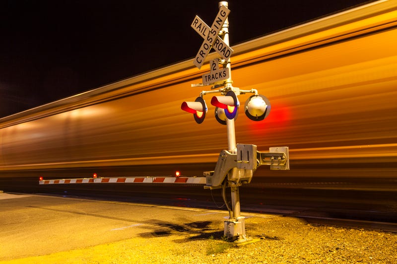 train passes a railway crossing at night