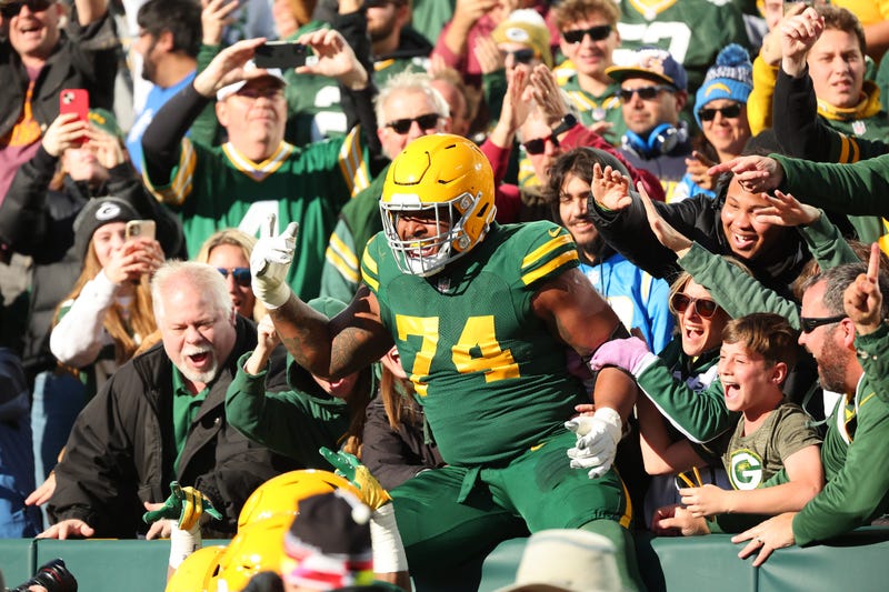 Elgton Jenkins #74 of the Green Bay Packers celebrates with fans after Jayden Reed #11 scored a touchdown in the second quarter against the Los Angeles Chargers at Lambeau Field on November 19, 2023 in Green Bay, Wisconsin