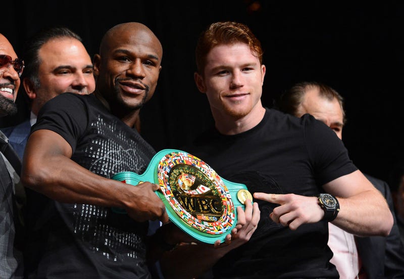 Boxers Floyd Mayweather Jr. (L) and Canelo Alvarez hold a WBC super welterweight championship belt during the final news conference for their bout at the MGM Grand Hotel/Casino on September 11, 2013 in Las Vegas, Nevada.