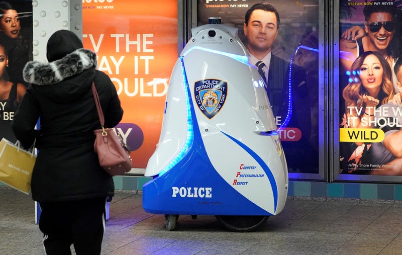 A woman looks at the K5 robot used by the New York City Police Department (NYPD) in the Times Square subway station on Nov. 28, 2023