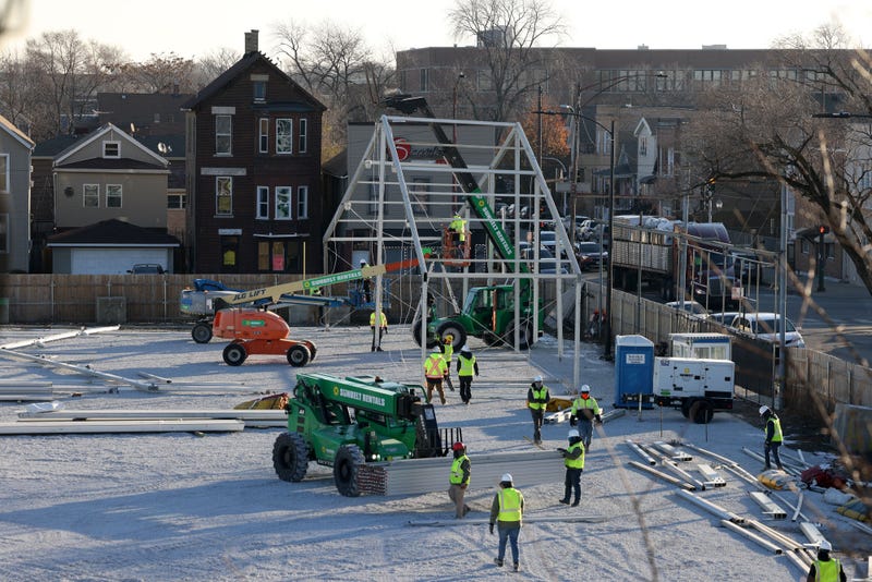 Workers erect a tent frame.