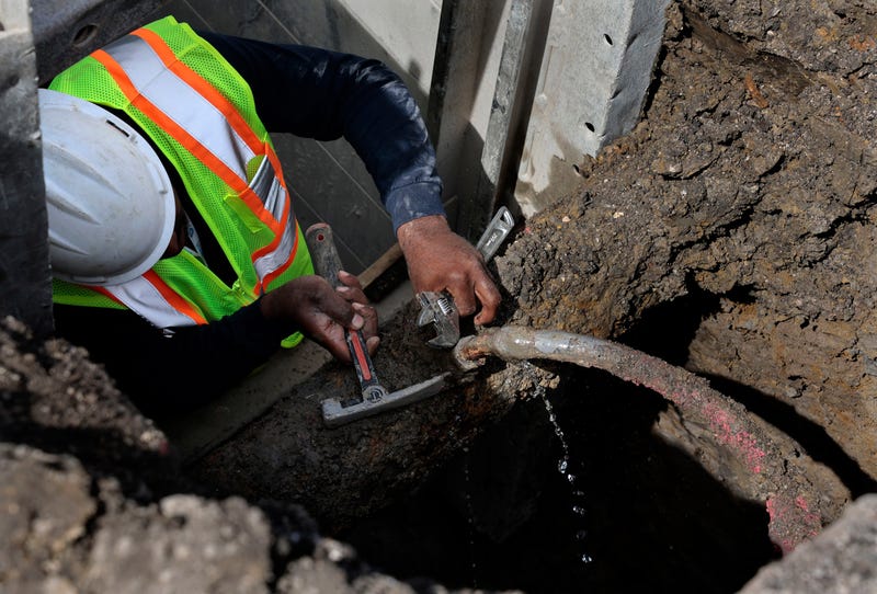 A contractor fixes a leaking lead service pipe ahead of service line replacement.