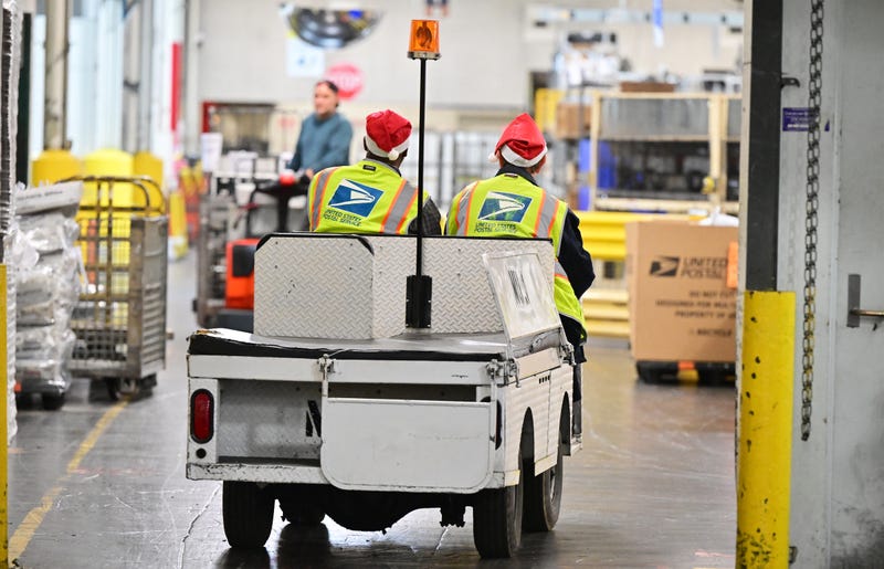 Postal workers wearing Santa hats drive through the facility during a media tour hosted by the U.S. Postal Service at the Los Angeles Processing and Distribution Center, the largest in the country, equivalent to 29 football fields, on Nov. 30, 2023.