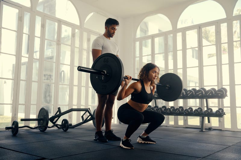 Two fit young adults in sports clothing doing weight training at the gym