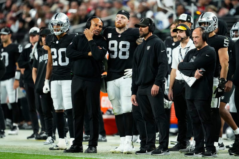Maxx Crosby #98 and Interim head coach Antonio Pierce of the Las Vegas Raiders talk on the sideline during the fourth quarter of a game against the Kansas City Chiefs at Allegiant Stadium on November 26, 2023