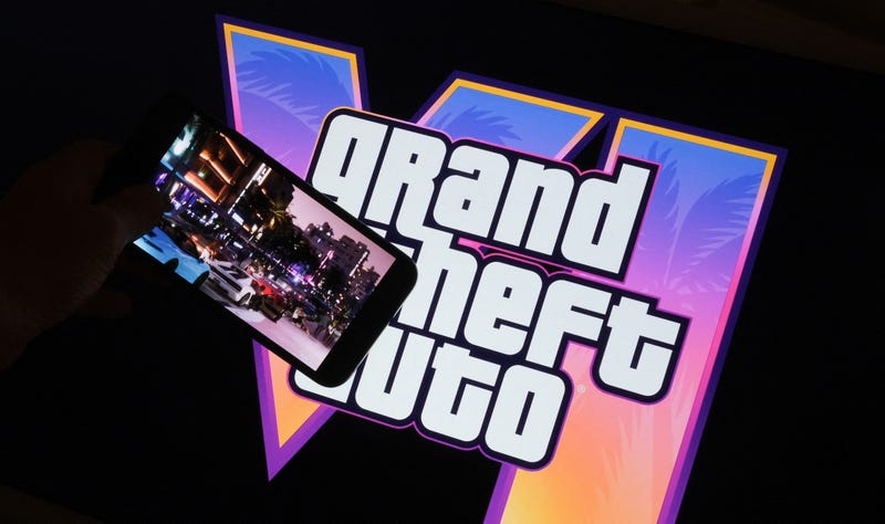 This illustration photo created in Los Angeles, December 4, 2023, shows Rockstar Games' Grand Theft Auto VI trailer played on a screen in front of the game title.