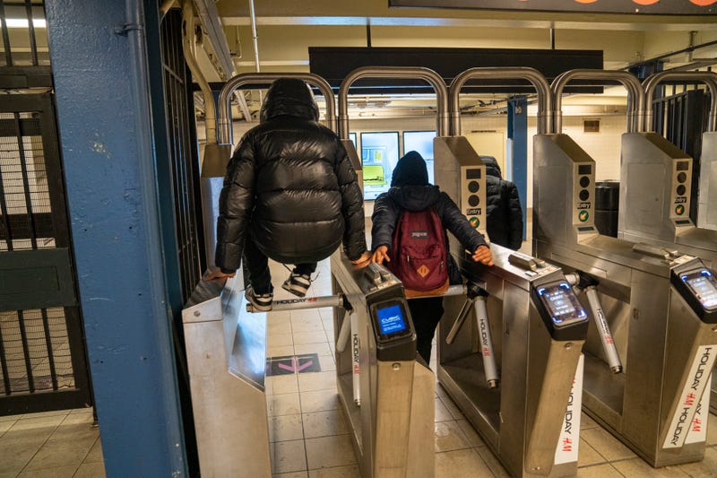 Teenagers jump turnstiles at a subway entrance Dec. 1, 2023