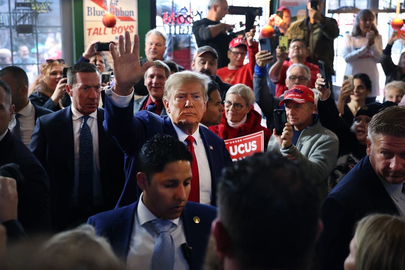 Republican presidential candidate Donald Trump greets guests as he arrives at a commit to caucus campaign event at the Whiskey River bar on Dec. 2, 2023, in Ankeny, Iowa