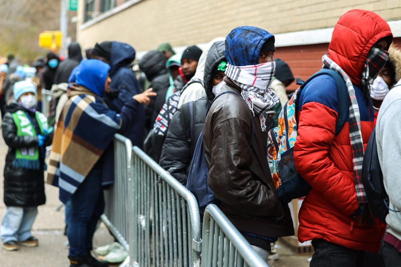 Asylum seekers line up outside the former St. Brigid School to apply for shelter in New York City on Dec. 7, 2023
