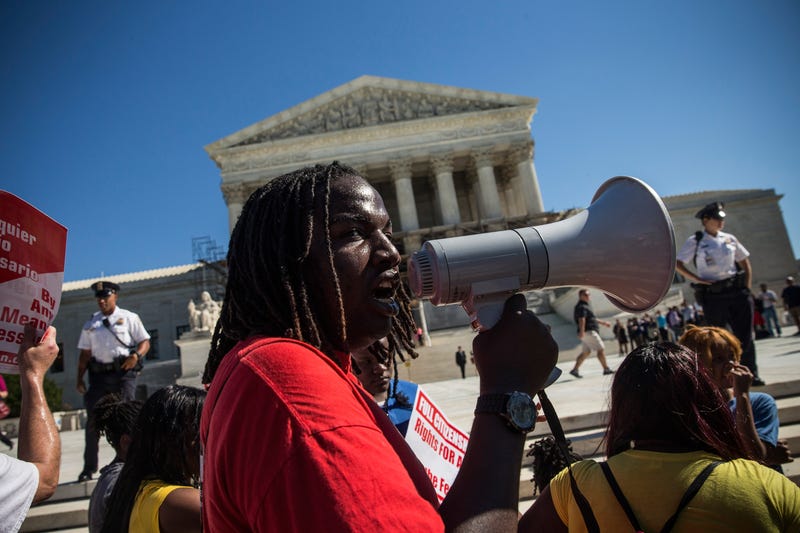 Tabrian Joe, a Sophomore at Western MIchigan University, leads a protest in support of affirmative action, outside the Supreme Court during the hearing of "Schuette v. Coalition to Defend Affirmative Action" on October 15, 2013 in Washington, DC.