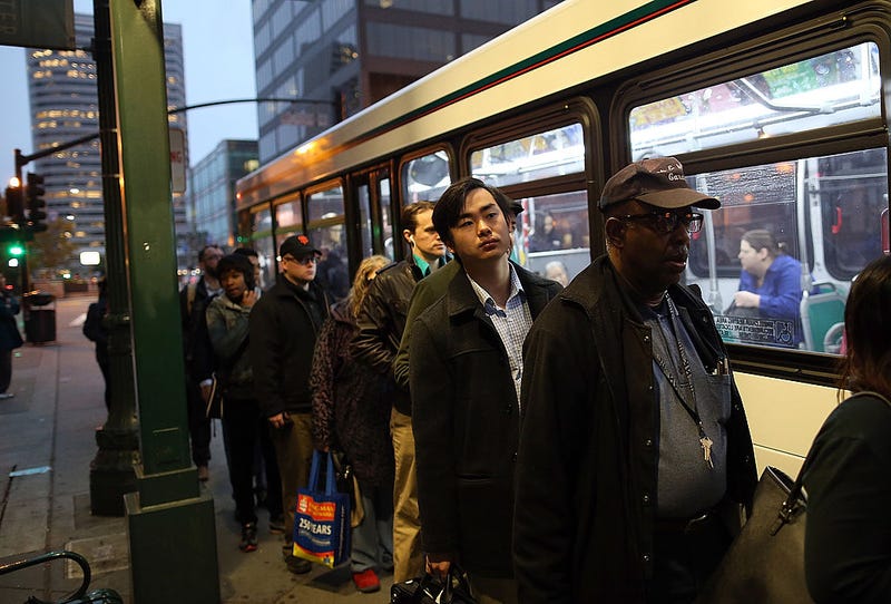 Commuters line up to board an AC Transit bus on October 21, 2013.